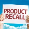 a person holding a sign that says "product recall"