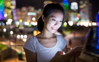 a woman sitting on a bench looking at her cell phone