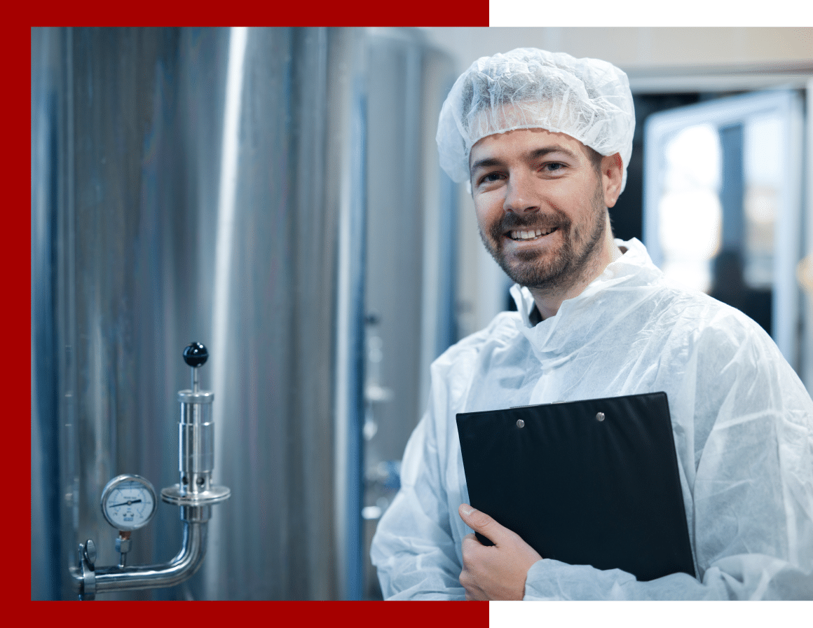 Employee wearing a hair net and PPE standing in a food production area.