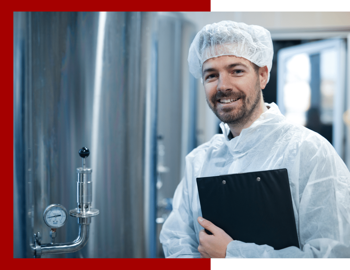 better-image Employee wearing a hair net and PPE standing in a food production area.