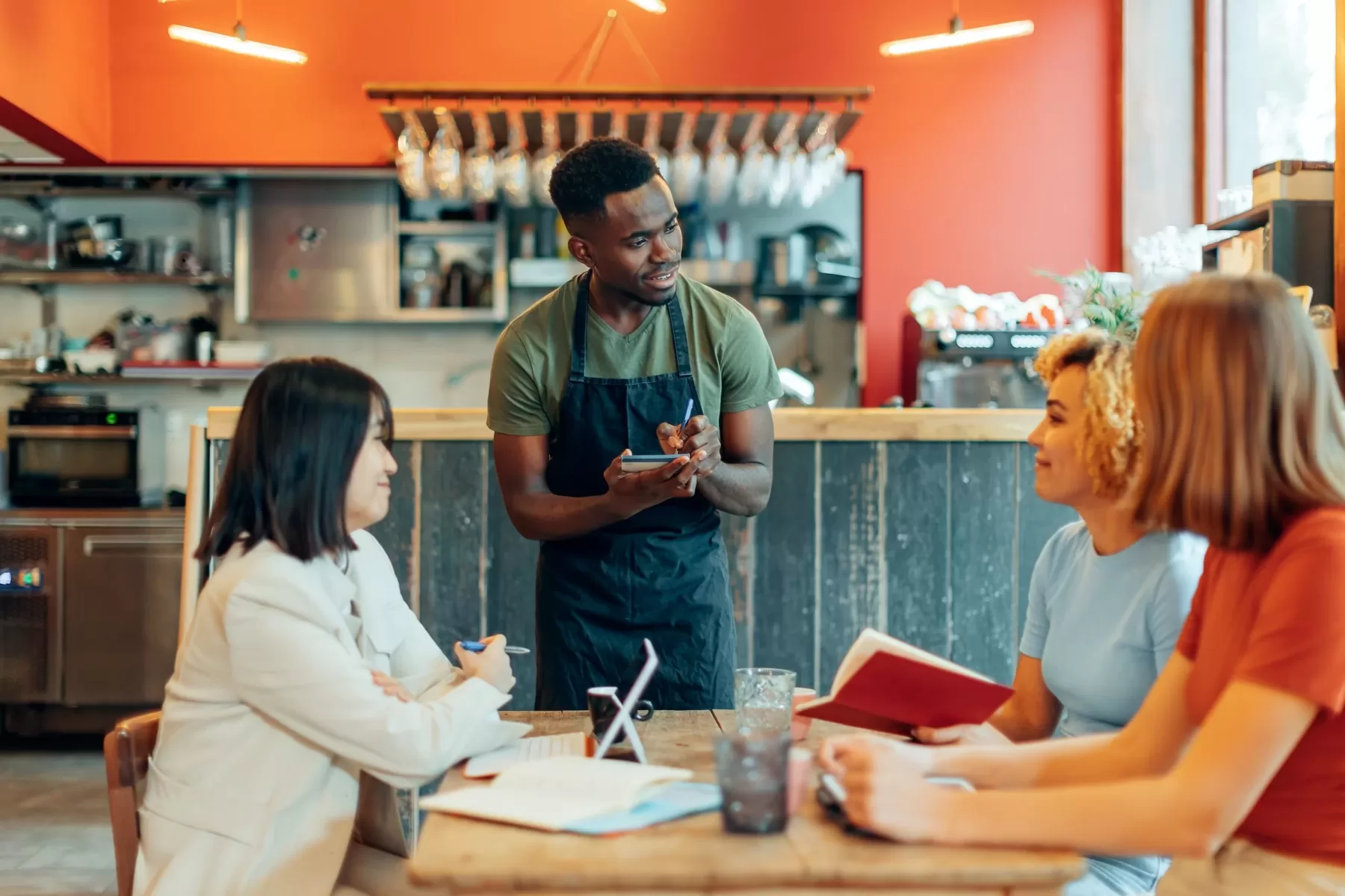 waiter taking order in a restaurant for three people